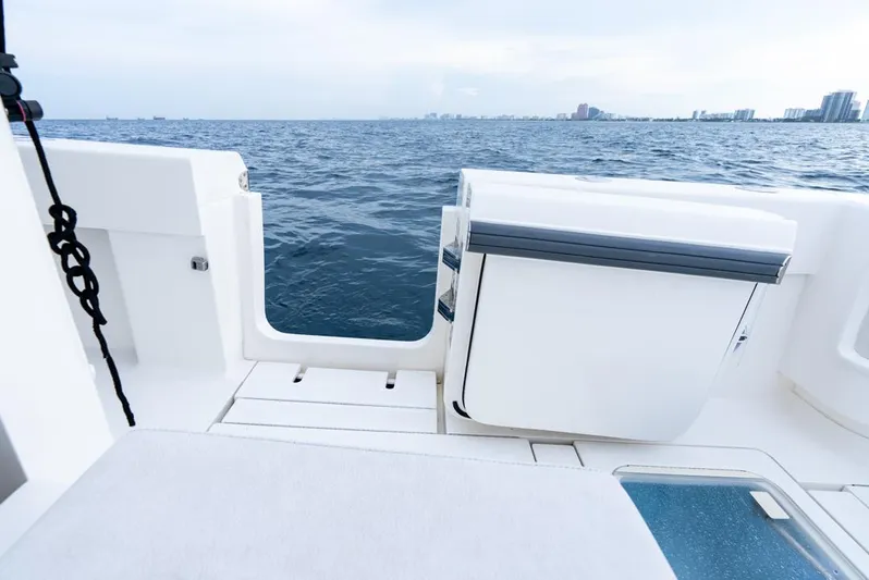  Yacht Photos Pics 2024 SeaVee 450z boat deck overlooking ocean with city skyline in background.