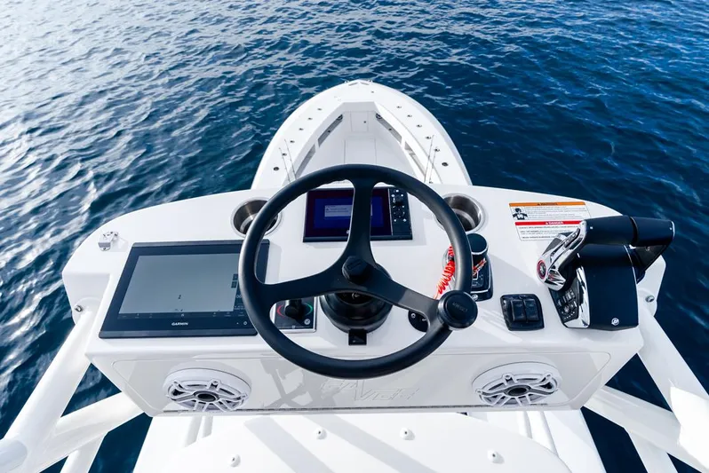  Yacht Photos Pics 2024 SeaVee 450z boat helm with steering wheel and navigation controls on open water.