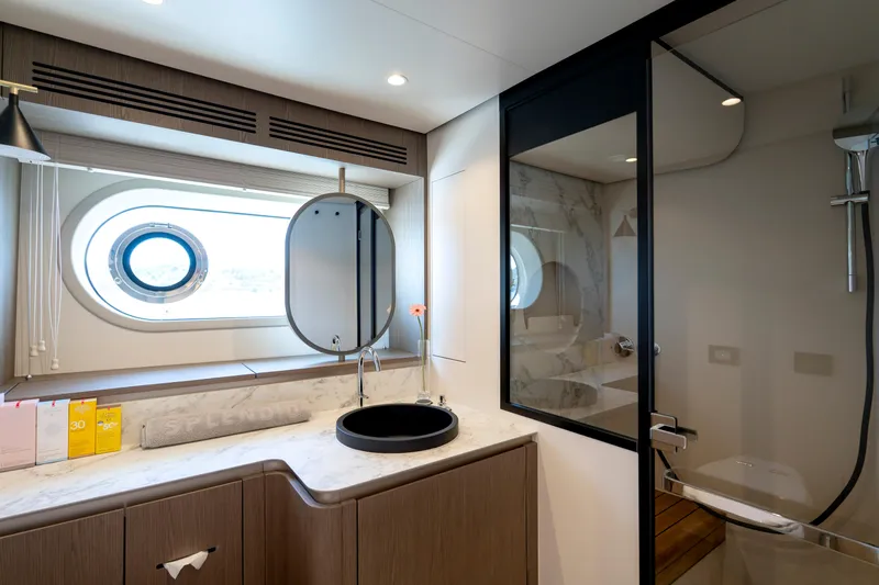 Olivia Yacht Photos Pics Luxurious bathroom interior of 2025 Azimut Magellano 60 yacht with modern fixtures and porthole window.