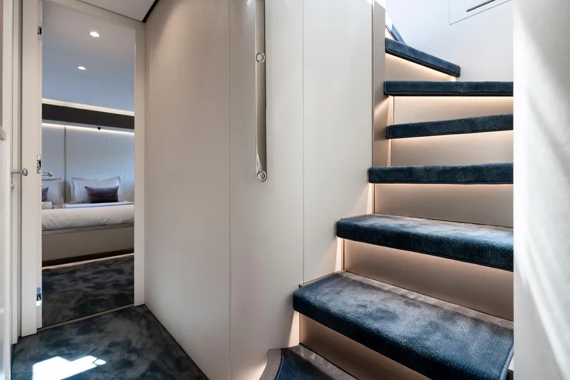 Olivia Yacht Photos Pics Luxurious interior of 2025 Azimut Magellano 60 yacht with elegant staircase and bedroom.