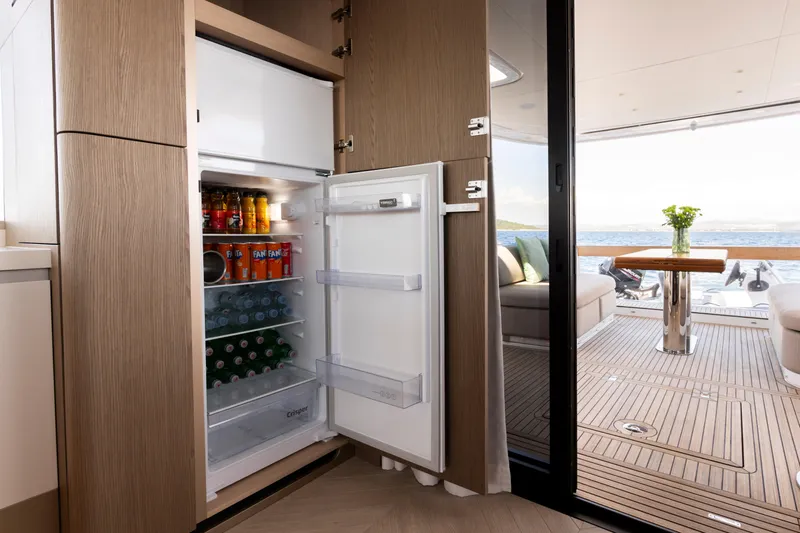 Olivia Yacht Photos Pics Open fridge on Azimut Magellano 60 yacht, stocked with drinks, overlooking deck and ocean view.