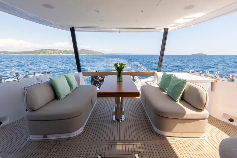 Olivia Yacht Photos Pics Luxurious Azimut Magellano 60 yacht interior with ocean view, featuring elegant seating and table.