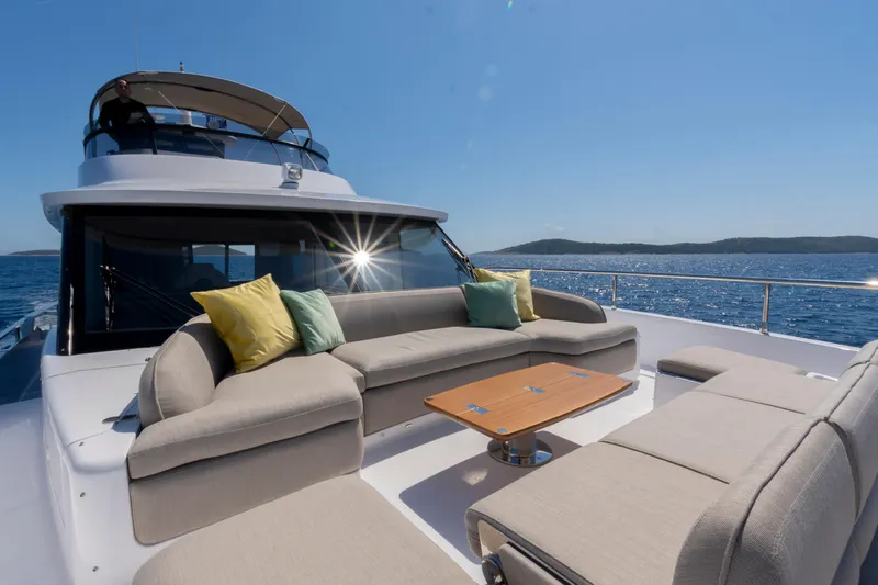 Olivia Yacht Photos Pics Luxurious 2025 Azimut Magellano 60 yacht with elegant outdoor seating on a sunny day.