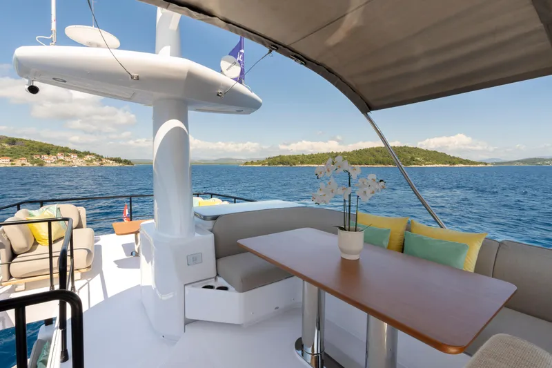 Olivia Yacht Photos Pics Luxurious 2025 Azimut Magellano 60 yacht deck with seating, table, and ocean view.