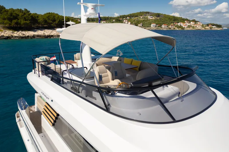 Olivia Yacht Photos Pics 2025 Azimut Magellano 60 yacht with sunshade, cruising near scenic coastline.