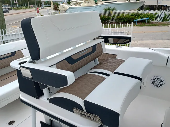  Yacht Photos Pics 2025 Blackfin 252 CC boat seating with white and brown upholstery, docked near a marina.