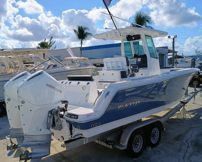  Yacht Photos Pics 2025 Blackfin 252 CC boat with dual Mercury engines on a trailer, under a sunny sky.