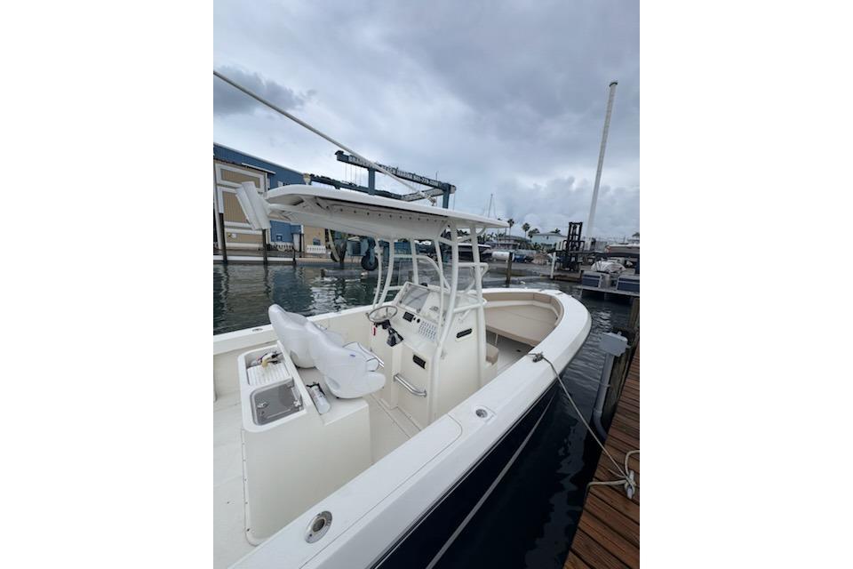 2017 Stamas 308 Predator boat docked at marina under cloudy sky.