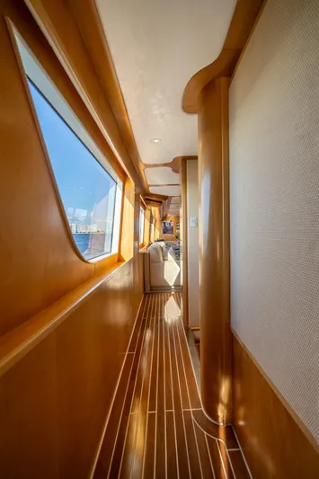 Destination Yacht Photos Pics Luxurious wooden interior hallway of a 2007 MCP Tri-Deck yacht with large windows.