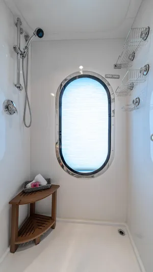 Destination Yacht Photos Pics Luxurious yacht shower with oval window, wooden corner shelf, and chrome fixtures. MCP Tri-Deck 2007.