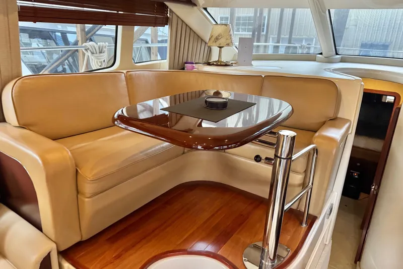 Barefoot Bliss Yacht Photos Pics Luxurious interior of 2007 Sea Ray 44 Sedan Bridge yacht with leather seating and wooden table.