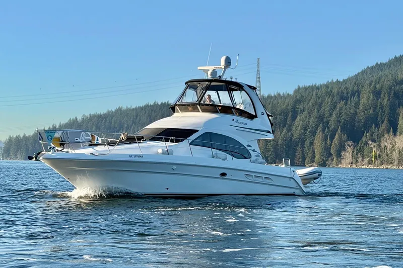 Barefoot Bliss Yacht Photos Pics 2007 Sea Ray 44 Sedan Bridge yacht cruising on a scenic lake with forested hills.