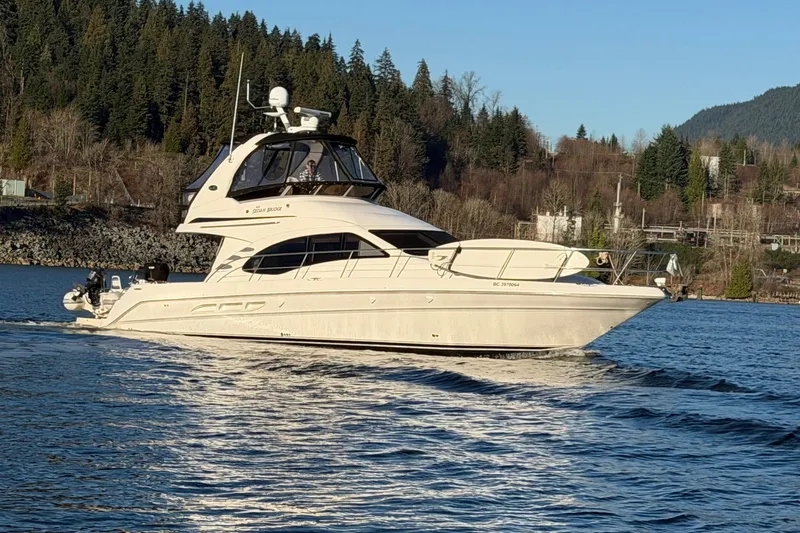 Barefoot Bliss Yacht Photos Pics 2007 Sea Ray 44 Sedan Bridge yacht cruising on a scenic lake with forested hills.