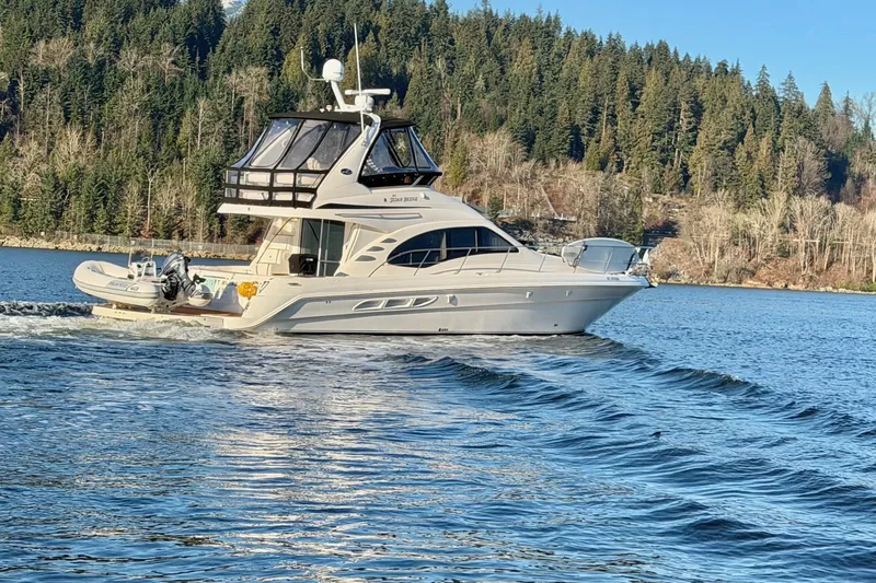 Barefoot Bliss Yacht Photos Pics 2007 Sea Ray 44 Sedan Bridge yacht cruising on a scenic lake with forested shoreline.