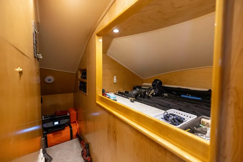 Mighty Mouse Yacht Photos Pics Storage area inside 2011 Viking 70 Convertible yacht, featuring wooden cabinetry and organized equipment.