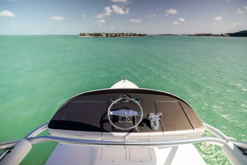 Mighty Mouse Yacht Photos Pics Viking 70 Convertible 2011 yacht helm overlooking turquoise sea and distant island.