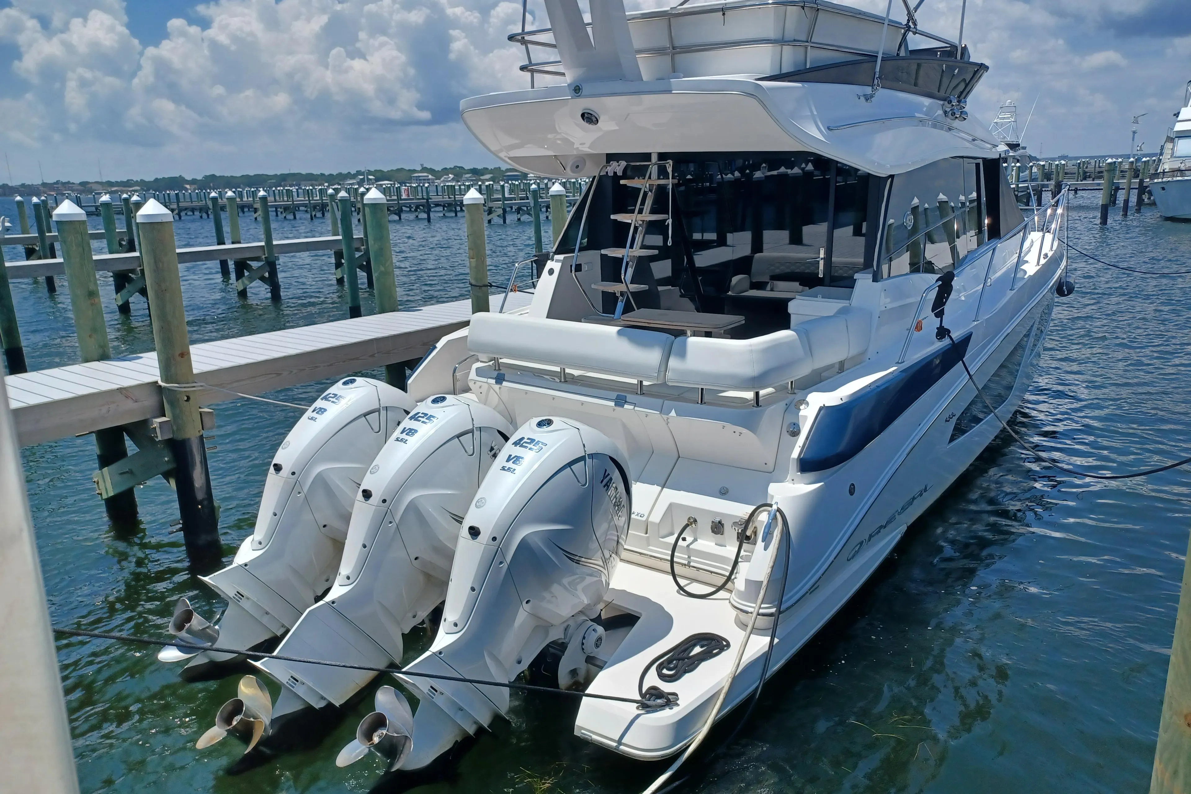 2023 Regal 42 FXO yacht docked with triple outboard engines.