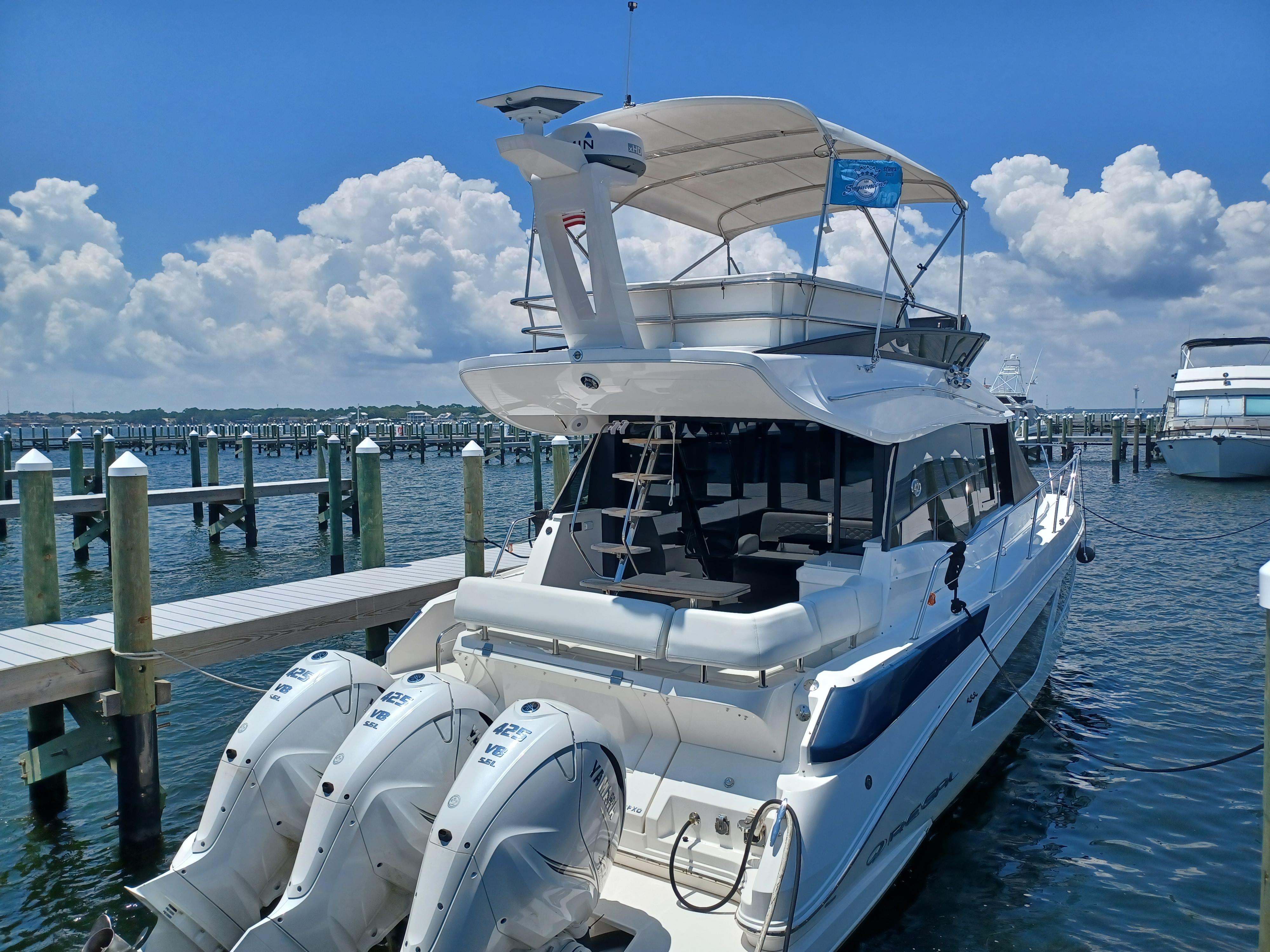 2023 Regal 42 FXO yacht docked at marina under clear blue sky.