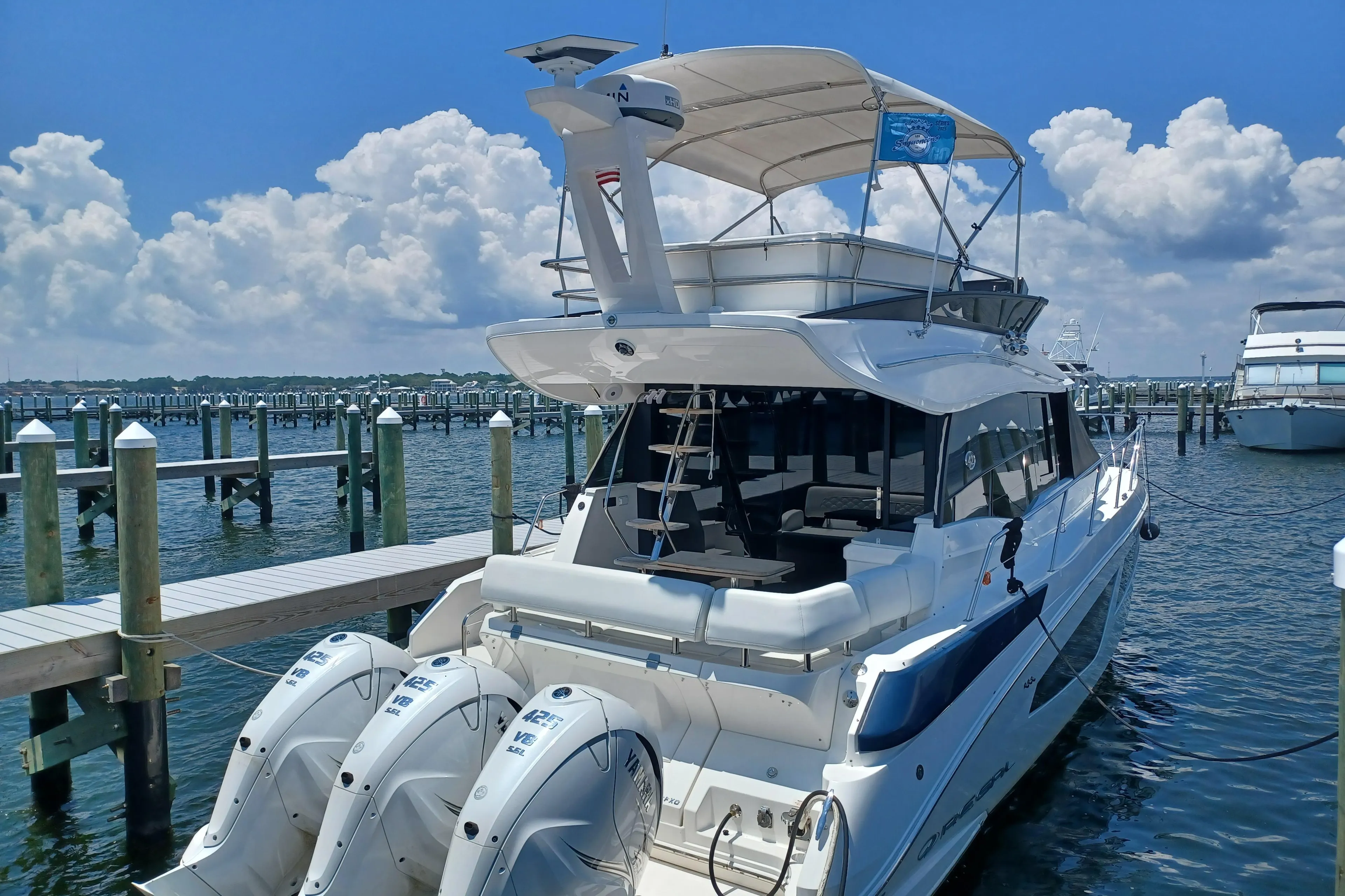 2023 Regal 42 FXO yacht docked at marina under clear blue sky.