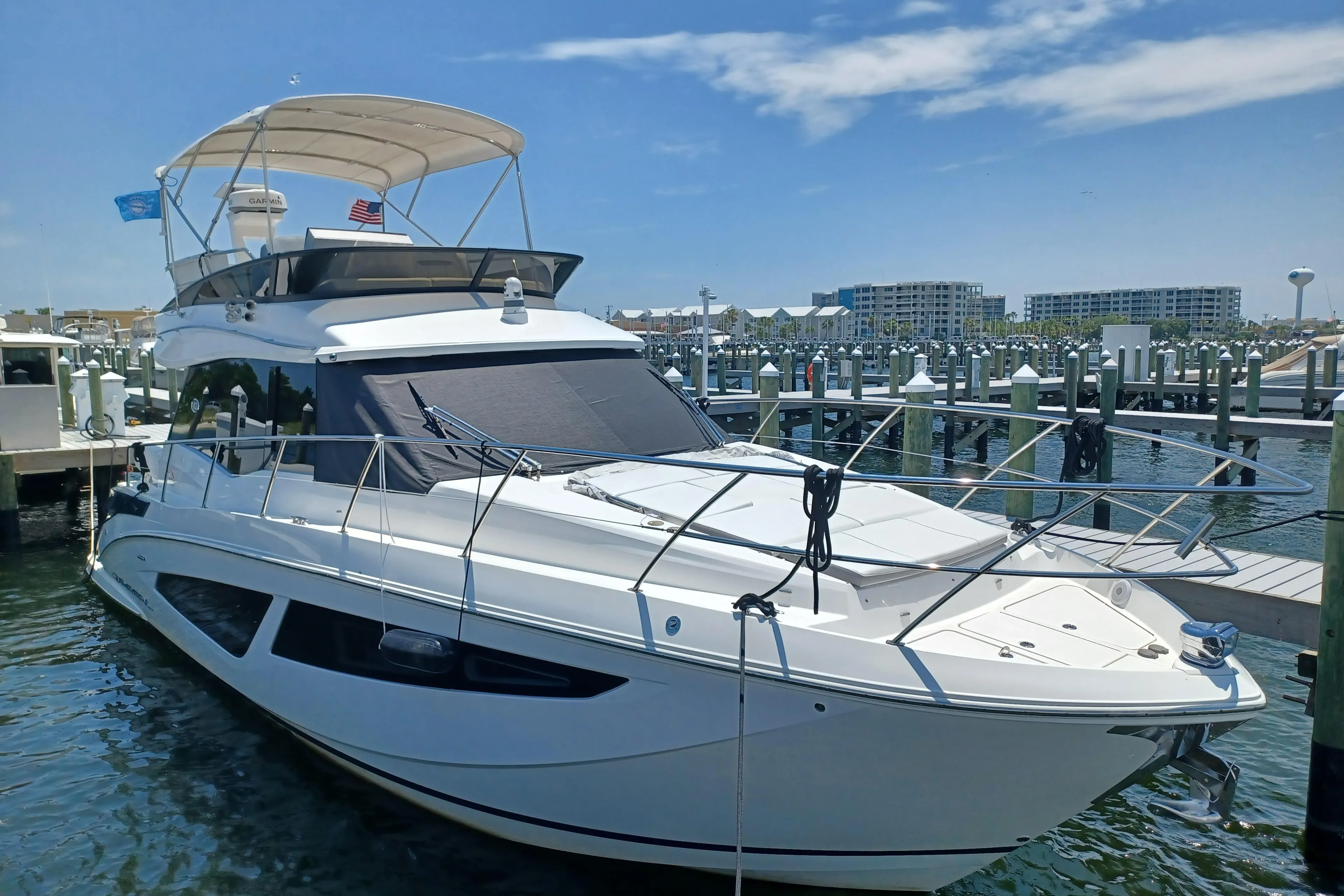 2023 Regal 42 FXO yacht docked at a marina under a clear blue sky.