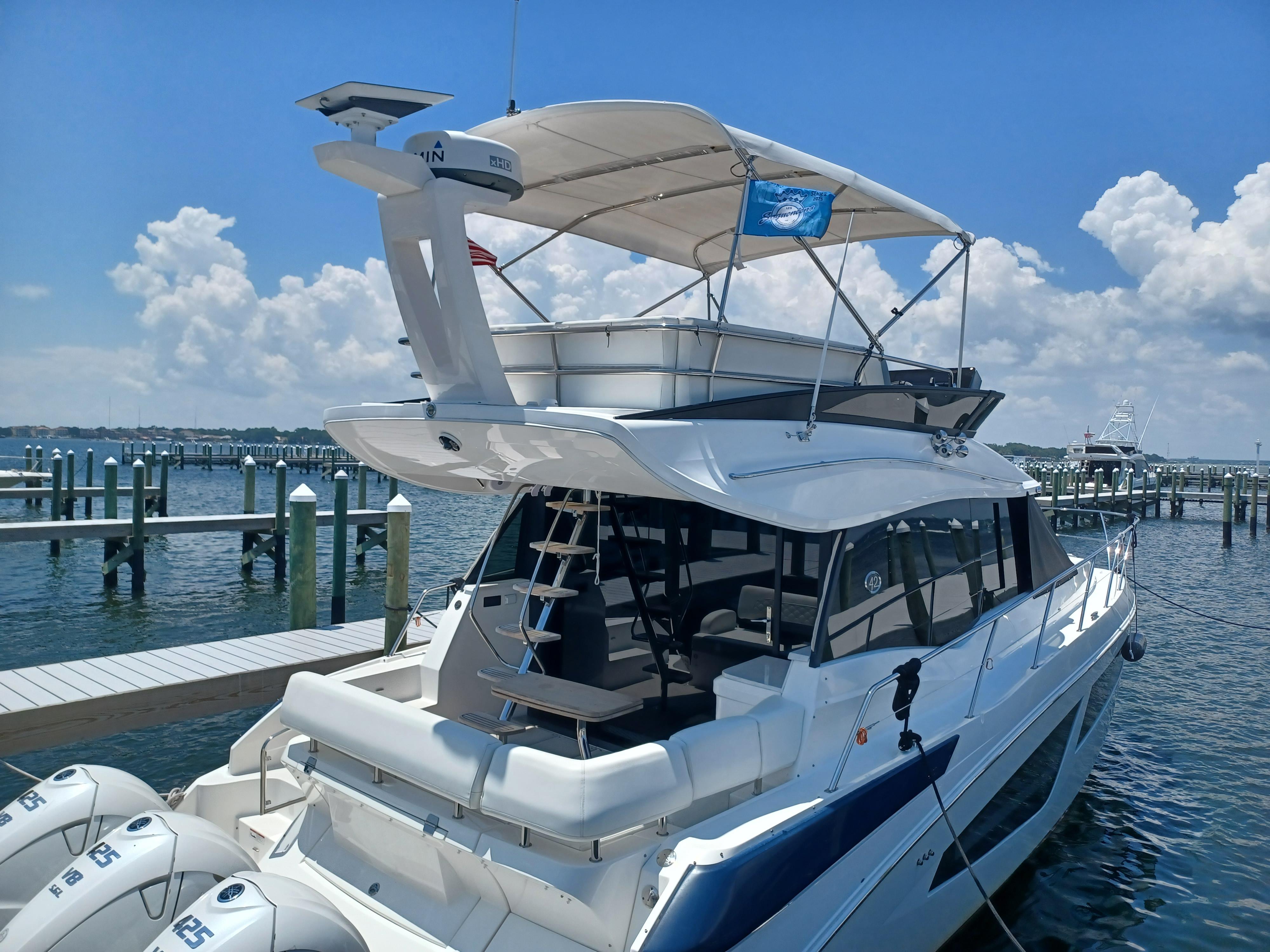 2023 Regal 42 FXO yacht docked at marina under clear blue sky.