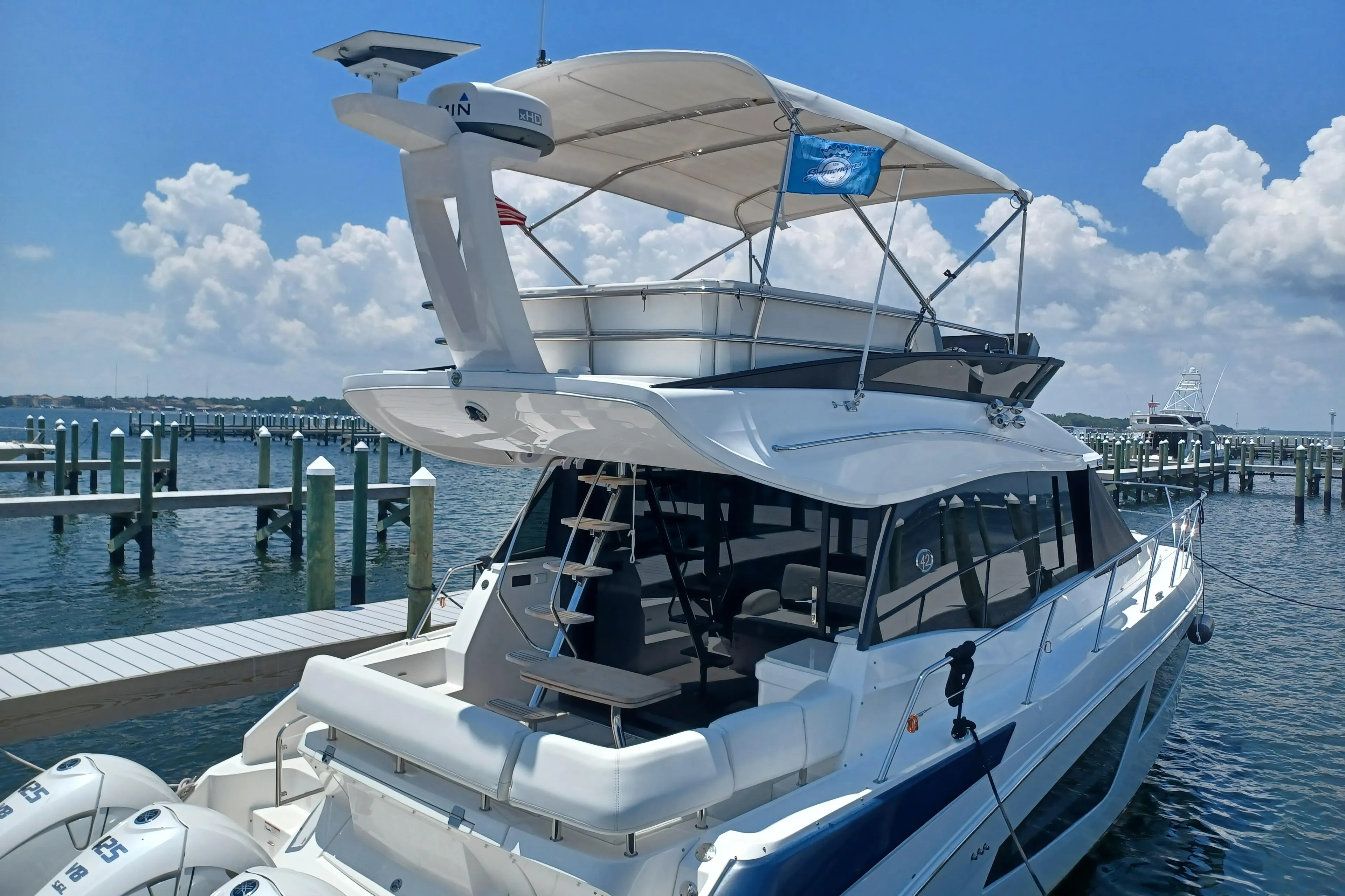2023 Regal 42 FXO yacht docked at marina under clear blue sky.