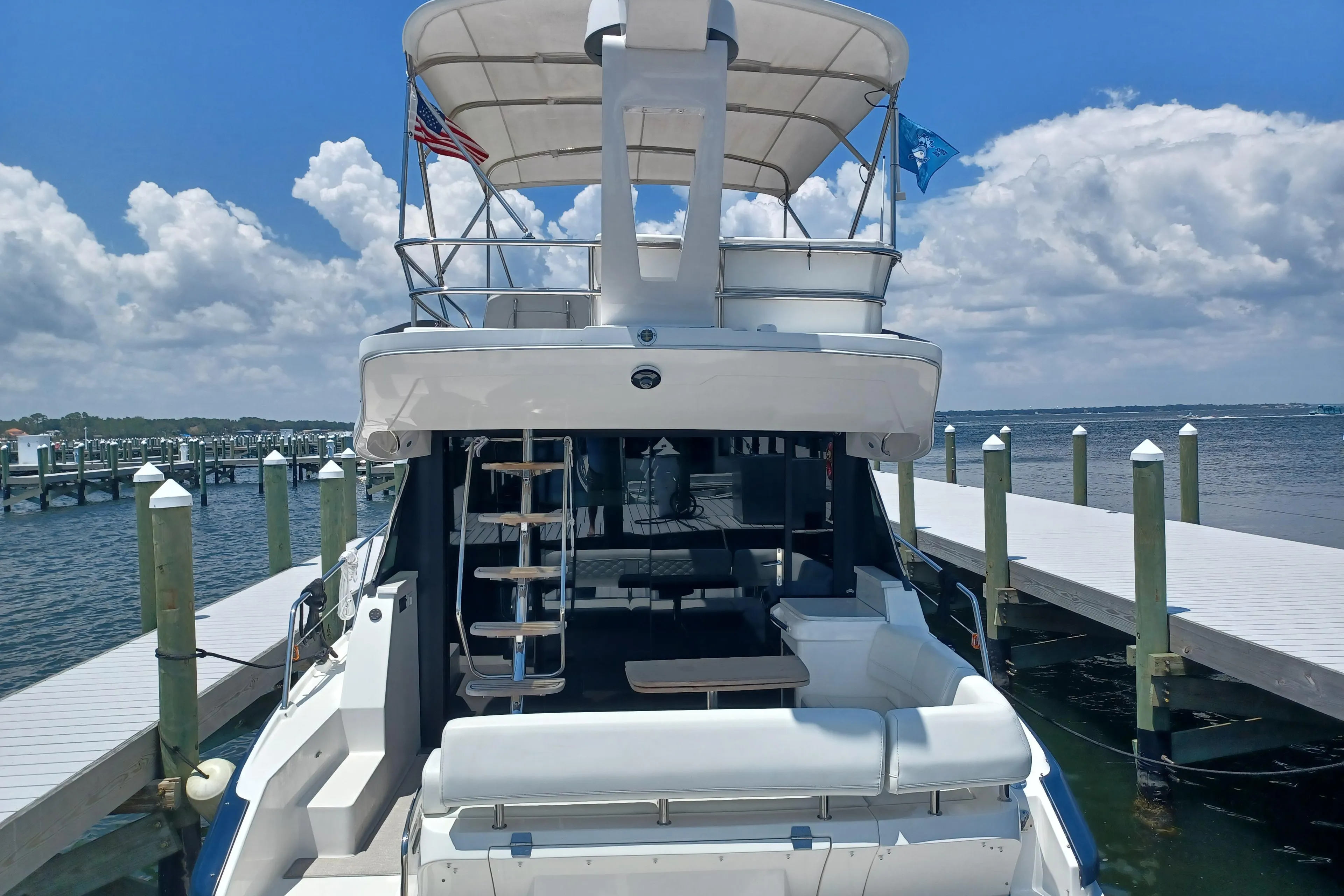 2023 Regal 42 FXO yacht docked at marina under clear blue sky.