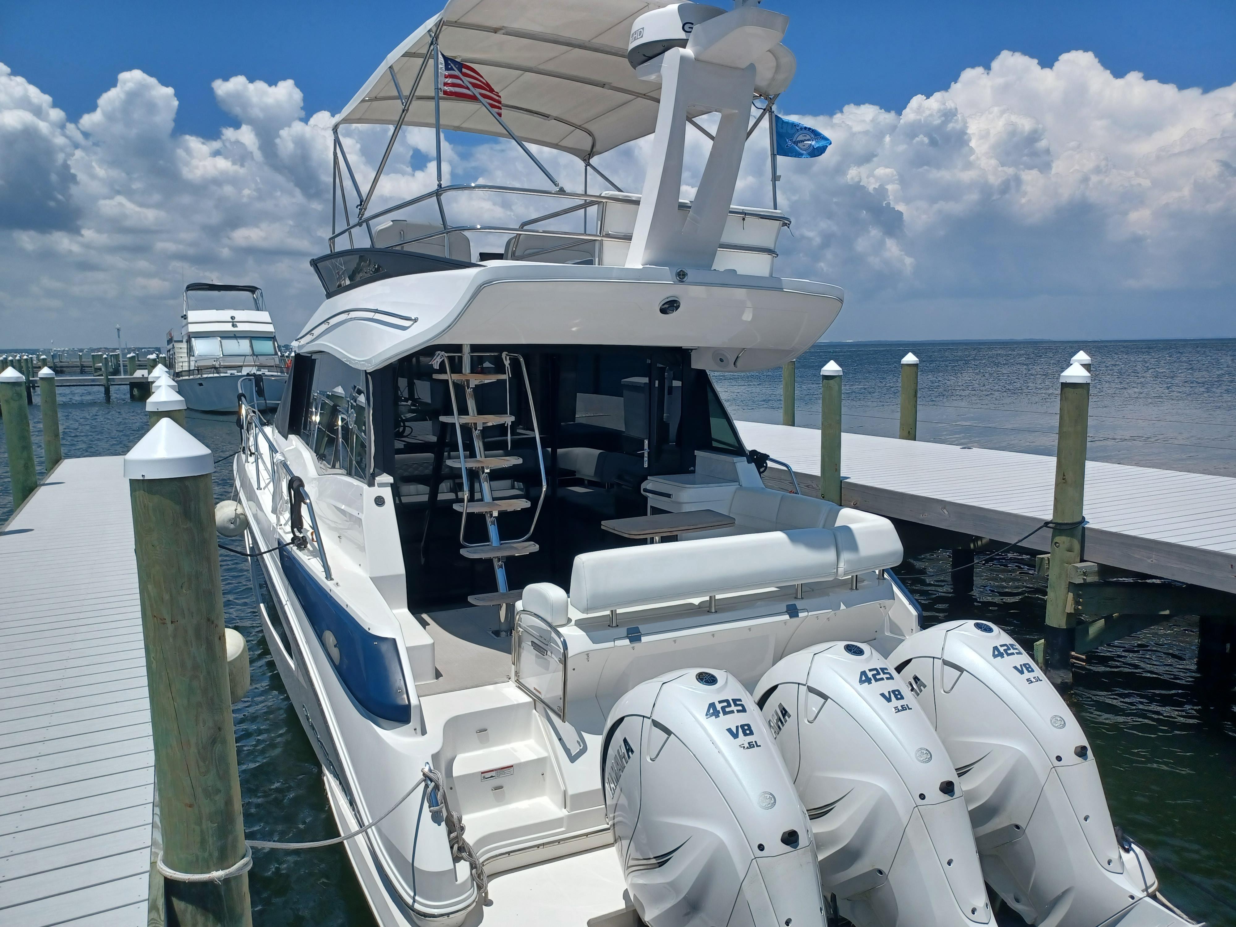 2023 Regal 42 FXO yacht docked, featuring triple Yamaha 425 V8 engines.