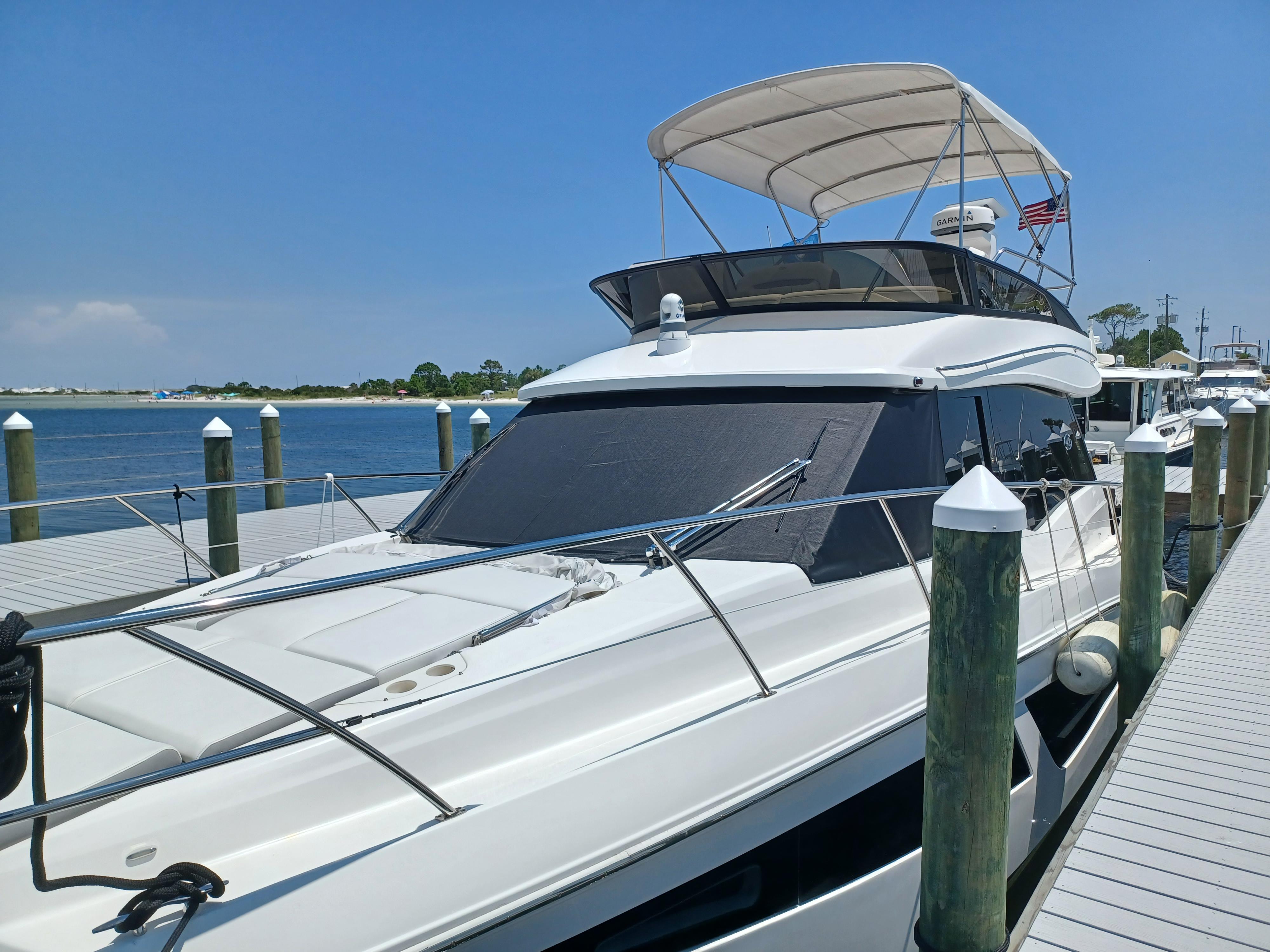 2023 Regal 42 FXO yacht docked at a marina under clear blue skies.