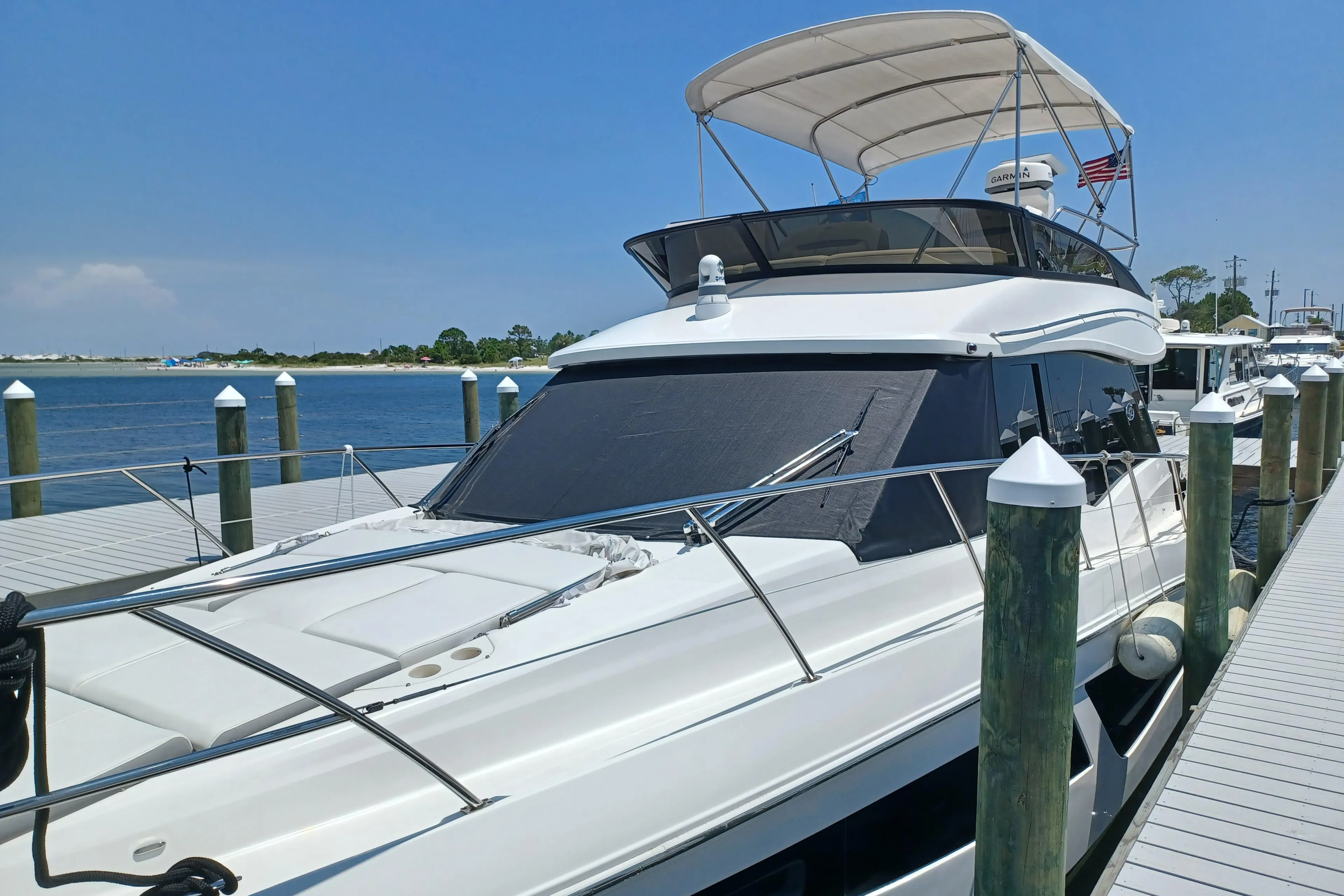 2023 Regal 42 FXO yacht docked at a marina under clear blue skies.