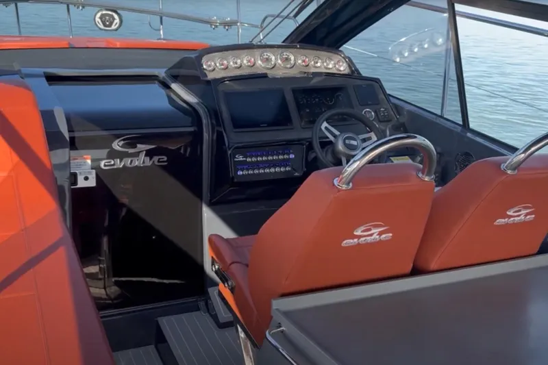  Yacht Photos Pics 2024 Evolve 400HT yacht cockpit with modern controls and red seating.