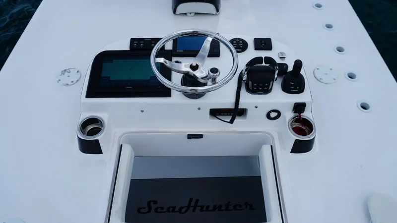  Yacht Photos Pics Control panel of 2018 SeaHunter 45 Tournament boat with steering wheel and navigation equipment.