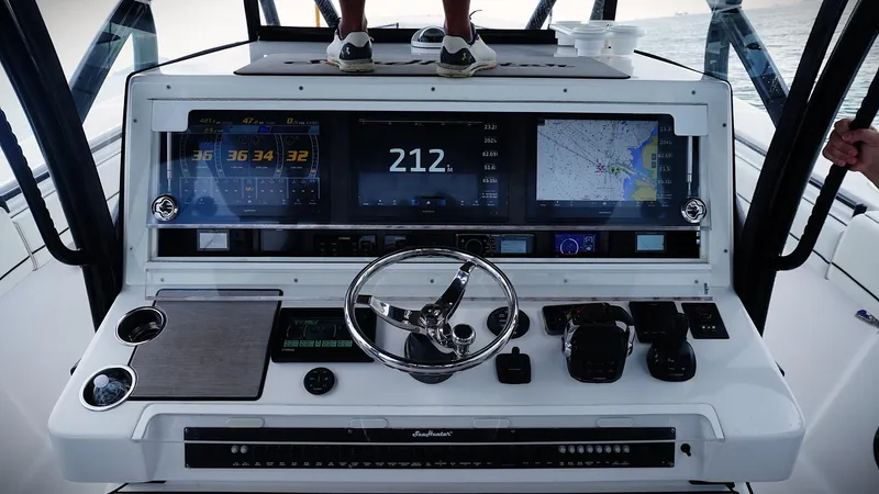  Yacht Photos Pics Control panel of a 2018 SeaHunter 45 Tournament boat with navigation screens and steering wheel.