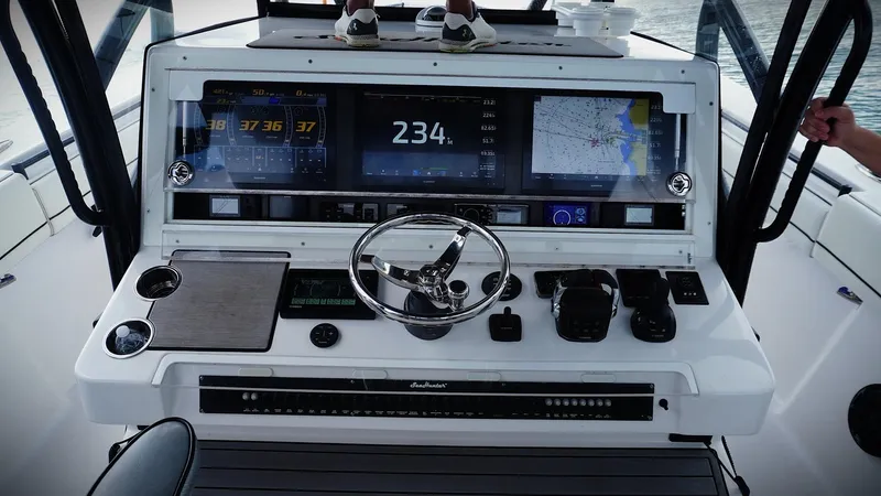  Yacht Photos Pics Control panel of a 2018 SeaHunter 45 Tournament boat with navigation screens and steering wheel.