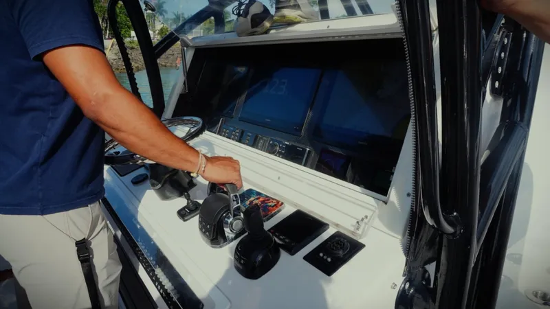  Yacht Photos Pics Man operating 2018 SeaHunter 45 Tournament boat controls, featuring advanced navigation systems.