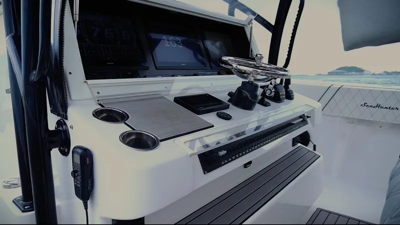  Yacht Photos Pics Control panel of a 2018 SeaHunter 45 Tournament boat with steering wheel and electronic displays.