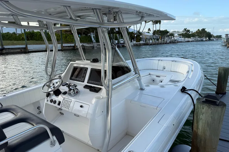  Yacht Photos Pics 2013 Intrepid 327 Cuddy boat docked, featuring sleek design and modern controls.