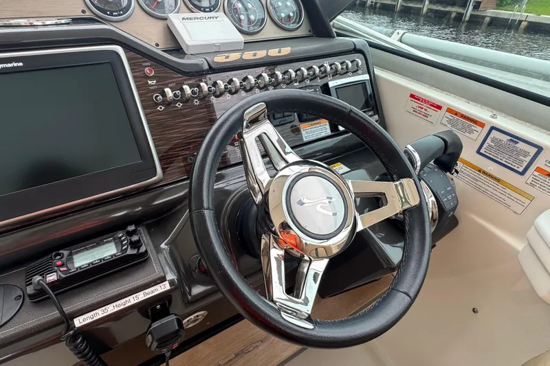  Yacht Photos Pics 2016 Sea Ray 350 Sundancer helm with steering wheel, controls, and navigation display.