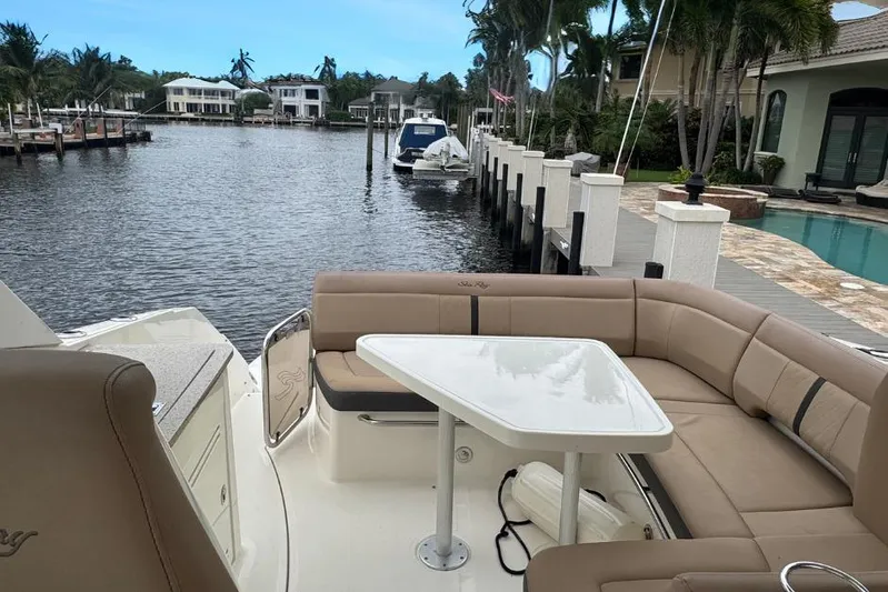  Yacht Photos Pics 2016 Sea Ray 350 Sundancer yacht with spacious seating and table, docked by waterfront homes.