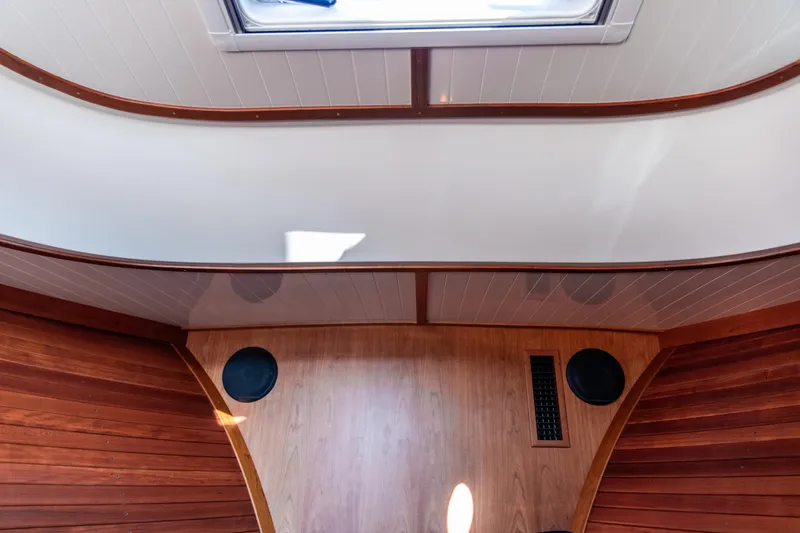 Leodes Yacht Photos Pics Interior view of 2022 Hinckley Picnic Boat 34 S, featuring wood paneling and ceiling hatch.
