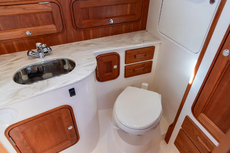 Leodes Yacht Photos Pics 2022 Hinckley Picnic Boat 34 S bathroom with wooden cabinetry and modern fixtures.