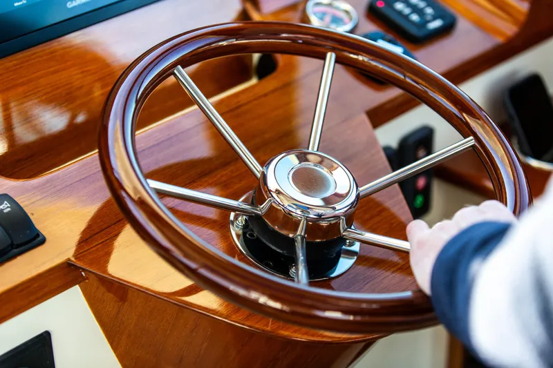 Leodes Yacht Photos Pics Steering wheel of 2022 Hinckley Picnic Boat 34 S, featuring polished wood and metal design.