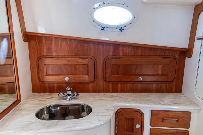 Leodes Yacht Photos Pics Hinckley Picnic Boat 34 S 2022 interior with wooden cabinetry and sink.