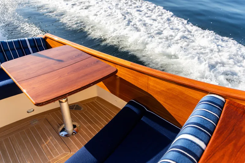 Leodes Yacht Photos Pics 2022 Hinckley Picnic Boat 34 S with elegant wooden table and cushioned seating.