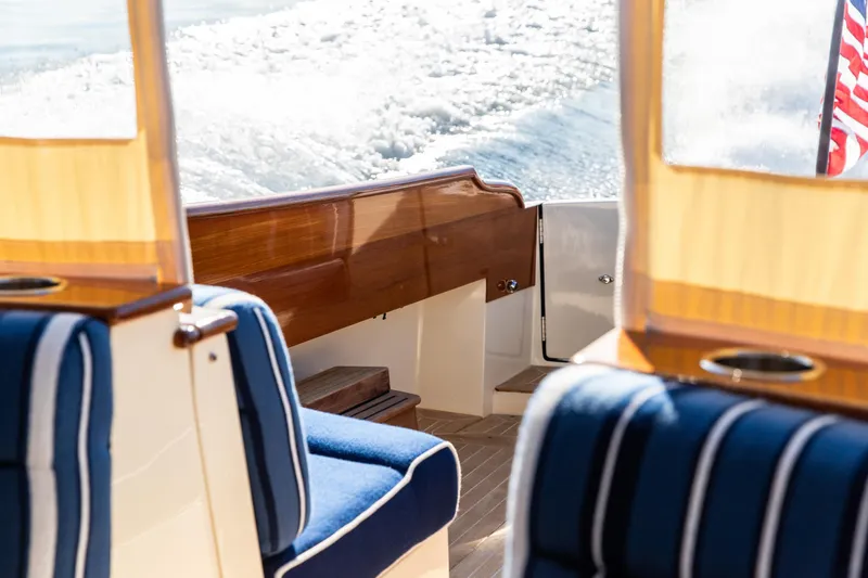 Leodes Yacht Photos Pics Hinckley Picnic Boat 34 S interior, 2022 model, featuring elegant wood and blue-striped seating.