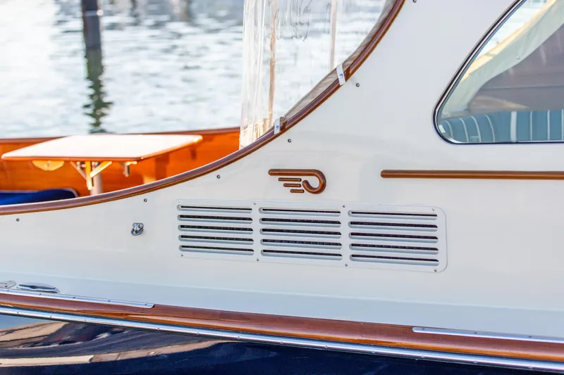 Leodes Yacht Photos Pics 2022 Hinckley Picnic Boat 34 S, elegant design with wood accents, docked by the water.