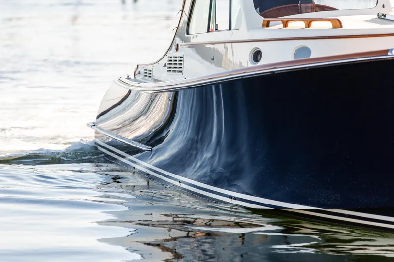 Leodes Yacht Photos Pics 2022 Hinckley Picnic Boat 34 S cruising on calm water, showcasing sleek design.