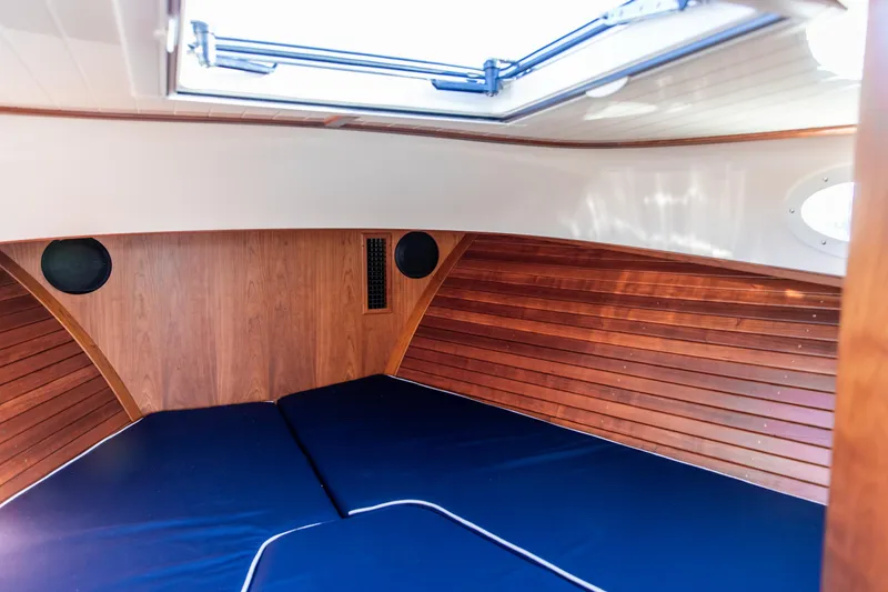 Leodes Yacht Photos Pics 2022 Hinckley Picnic Boat 34 S interior cabin with wood paneling and blue cushions.