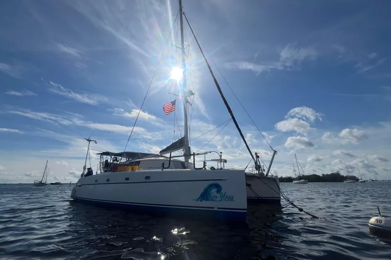 Sea Glass Yacht Photos Pics 2000 Fountaine Pajot Belize 43 catamaran sailing on a sunny day with American flag.