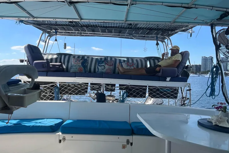 Sea Glass Yacht Photos Pics Man relaxing on Fountaine Pajot Belize 43 catamaran, enjoying waterfront view.